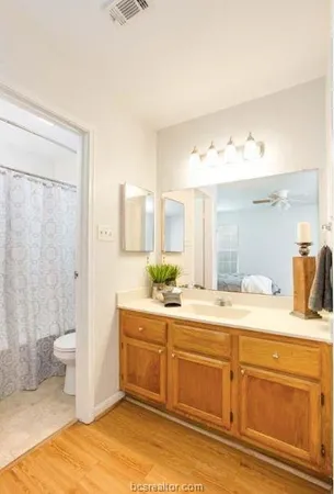 a spacious bathroom with a granite countertop sink and a mirror