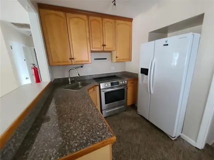 a kitchen with stainless steel appliances granite countertop a refrigerator sink and stove