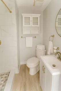 a bathroom with a toilet sink and mirror