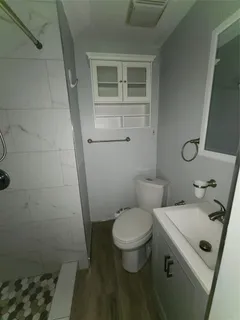 a bathroom with a sink toilet and shower