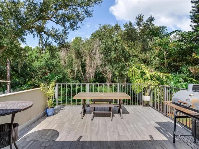 a balcony with wooden floor table and chairs