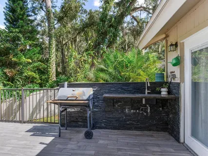 a view of an empty room with wooden floor a fireplace and a window