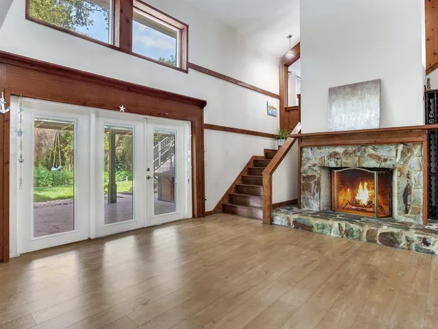 a living room with wooden floor and a fireplace