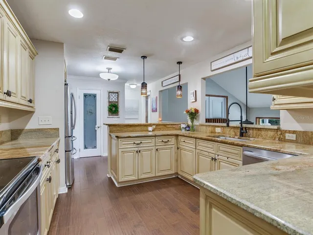 a kitchen with stainless steel appliances a sink stove and refrigerator