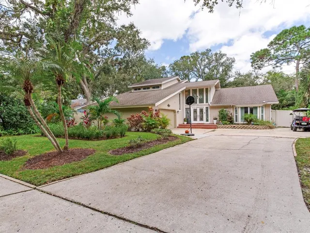 a front view of a house with a yard and trees