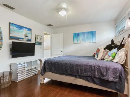 a view of a hallway with wooden floor and a bathroom