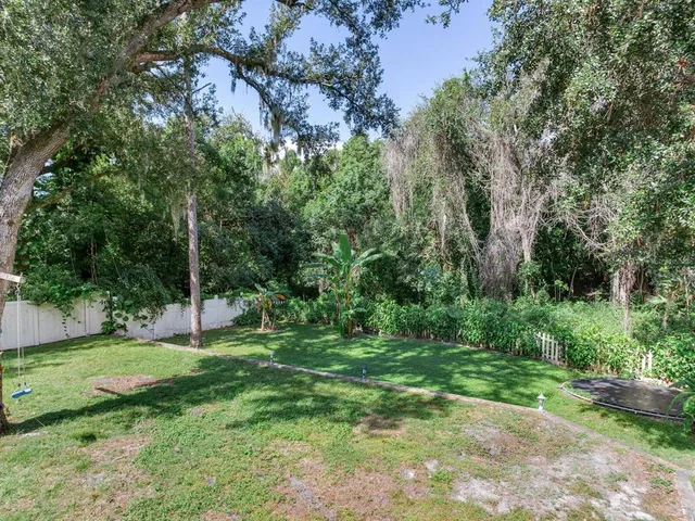 a view of a grassy field with trees in the background