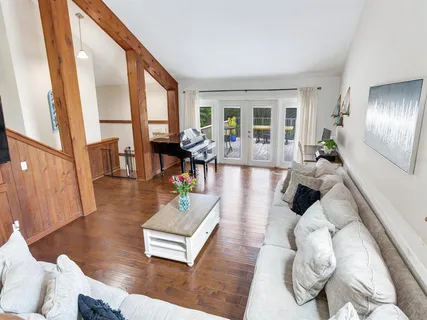 a living room with furniture large window and wooden floor