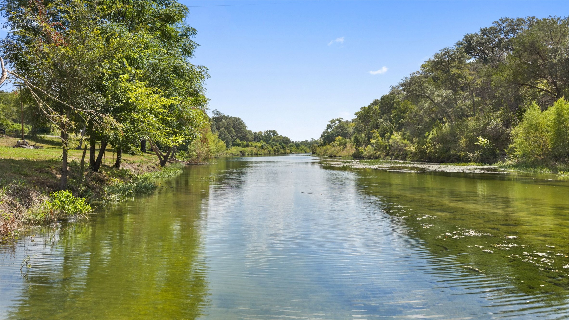 3764 Ranch Road 1623 Blanco, TX 78606 - Photo 1 of 36 Mature trees line the tranquil waterfront, creating a serene natural boundary.