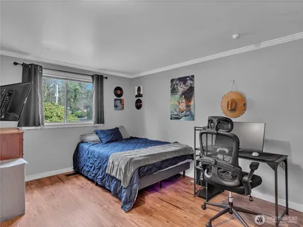 a bedroom with a bed and wooden floor