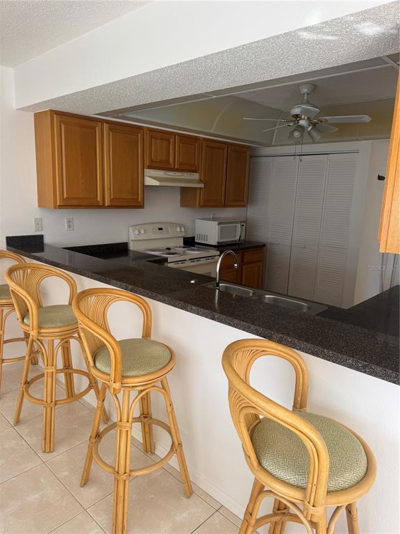 23465 Harbor View Road, Unit 201 Punta Gorda, FL 33980 - Photo 17 of 50 a kitchen with a table chairs sink and cabinets