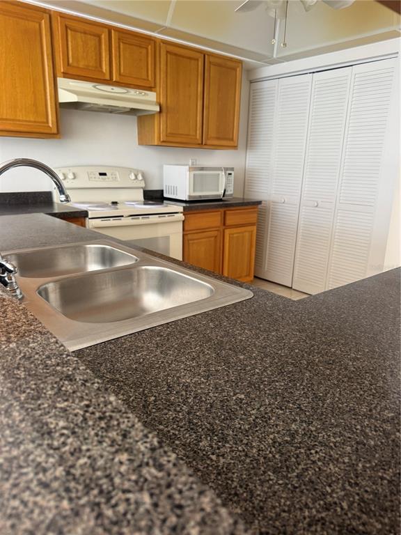 23465 Harbor View Road, Unit 201 Punta Gorda, FL 33980 - Photo 18 of 50 a kitchen with kitchen island a sink a stove and cabinets