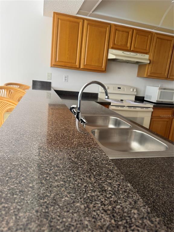 23465 Harbor View Road, Unit 201 Punta Gorda, FL 33980 - Photo 19 of 50 a kitchen with a sink a stove and cabinets