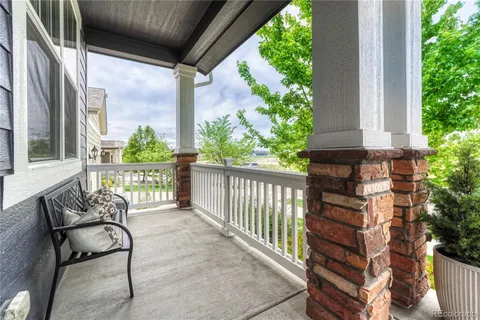 a balcony with chairs and with potted plants