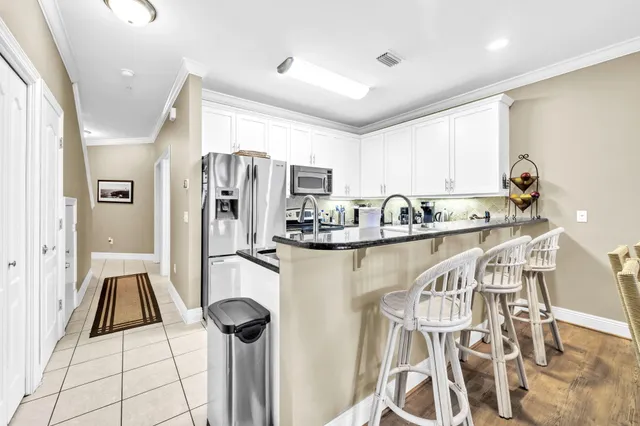 a kitchen with stainless steel appliances kitchen island granite countertop a refrigerator and a sink