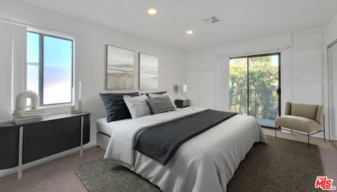 a bedroom with bed chair and window