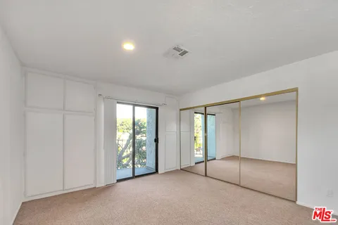 an empty room with windows and closet