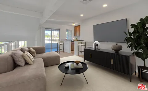 a living room with furniture a window and a potted plant