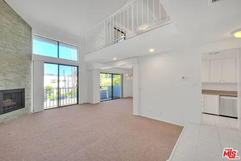 a view of an empty room with a window and fireplace