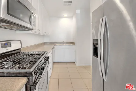 a kitchen with stainless steel appliances granite countertop a stove and a refrigerator