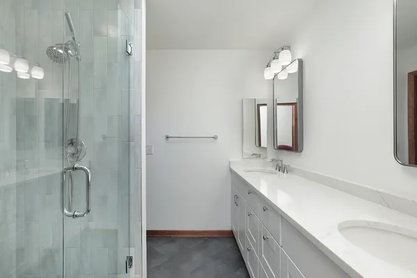 a bathroom with a double vanity sink a shower and a mirror