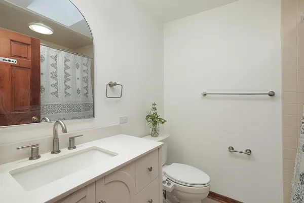 a bathroom with a sink toilet and a mirror