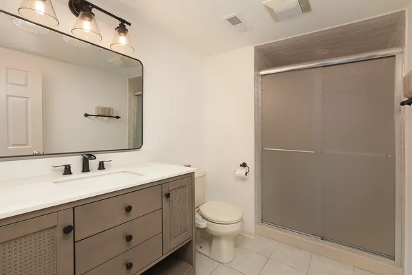a bathroom with a toilet sink vanity and mirror
