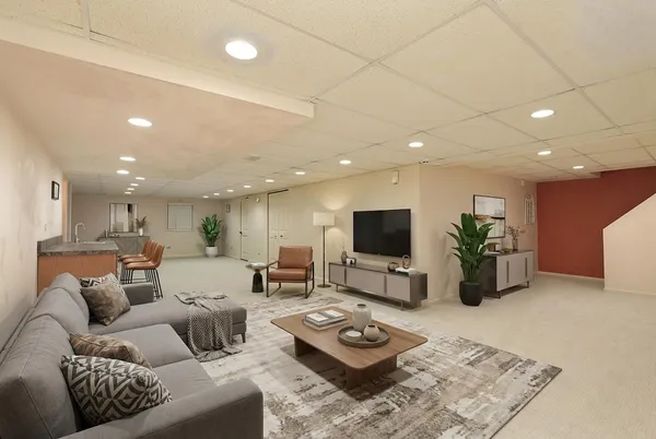 a living room with furniture a flat screen tv and a dining table with wooden floor