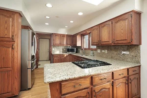 a kitchen with stainless steel appliances granite countertop a stove refrigerator and cabinets