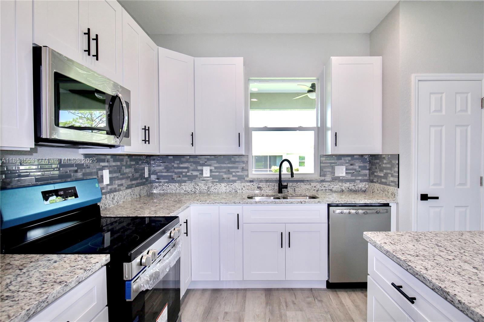 4631 Mignon Drive Sebring, FL 33872 - Photo 16 of 40 a kitchen with stainless steel appliances granite countertop a sink stove and microwave