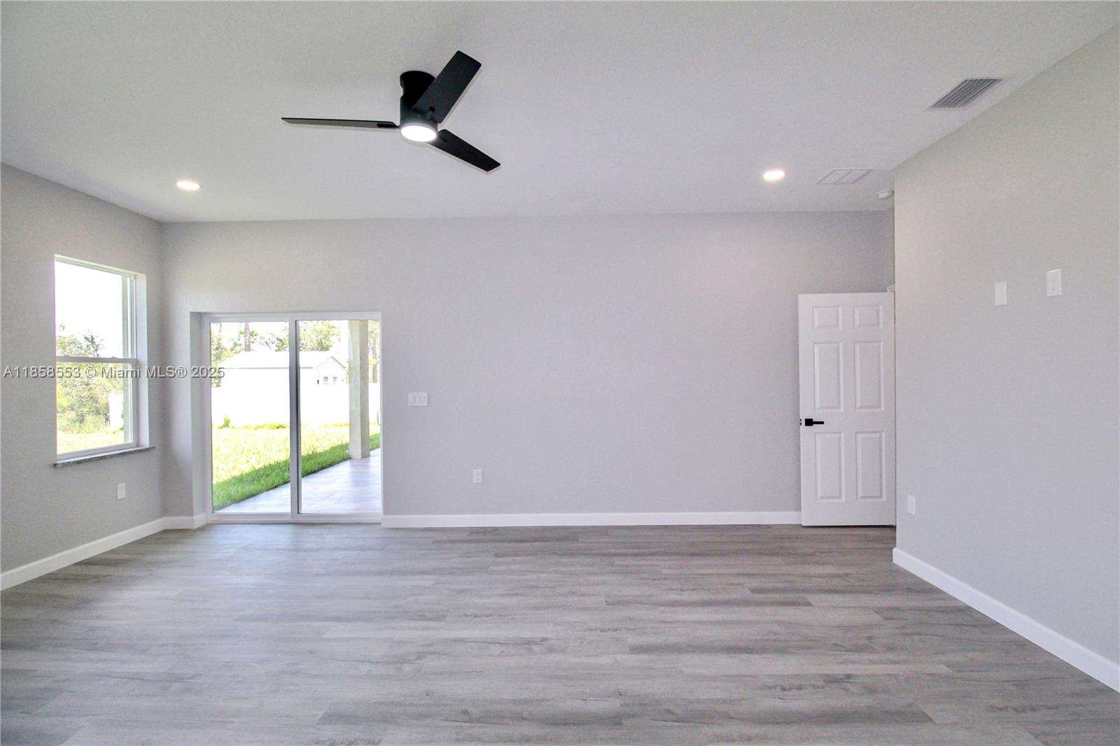 4631 Mignon Drive Sebring, FL 33872 - Photo 22 of 40 an empty room with wooden floor and windows