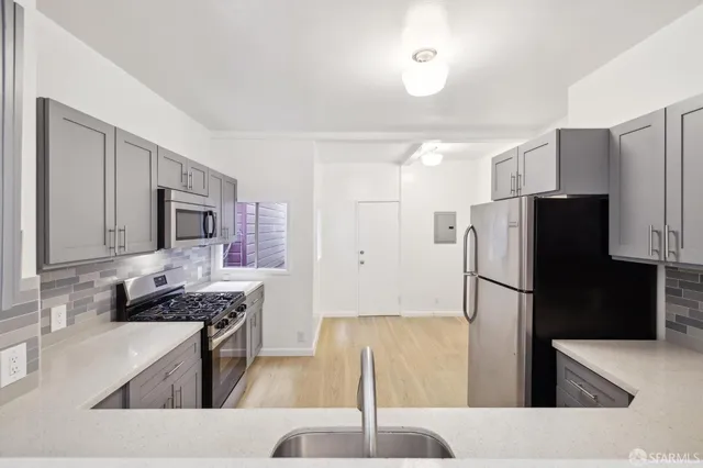 a kitchen with stainless steel appliances granite countertop a refrigerator stove and sink