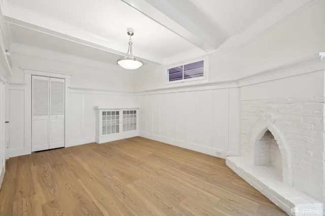 a view of empty room with wooden floor and ceiling fan