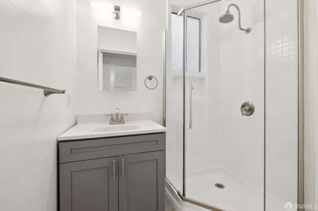 a bathroom with a granite countertop sink a shower and mirror