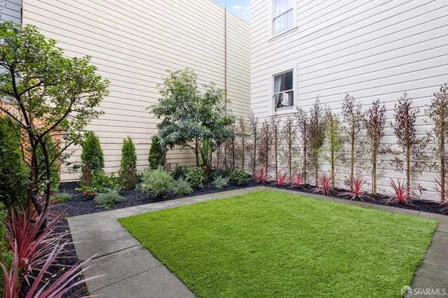 a view of a house with a yard and potted plants