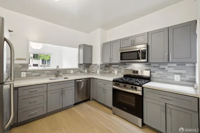 a kitchen with sink a microwave and cabinets