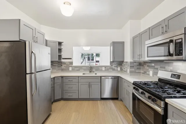 a kitchen with stainless steel appliances a stove a sink and a refrigerator