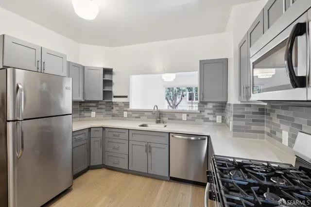 a kitchen with a sink a refrigerator and cabinets