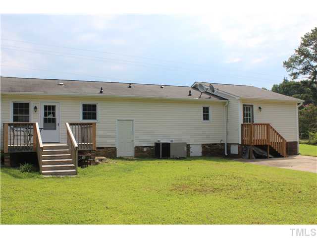 1685 Jack Road Clayton, NC 27520 - Photo 13 of 14 Back of house with deck and walk-in crawl space with concrete floor for storage