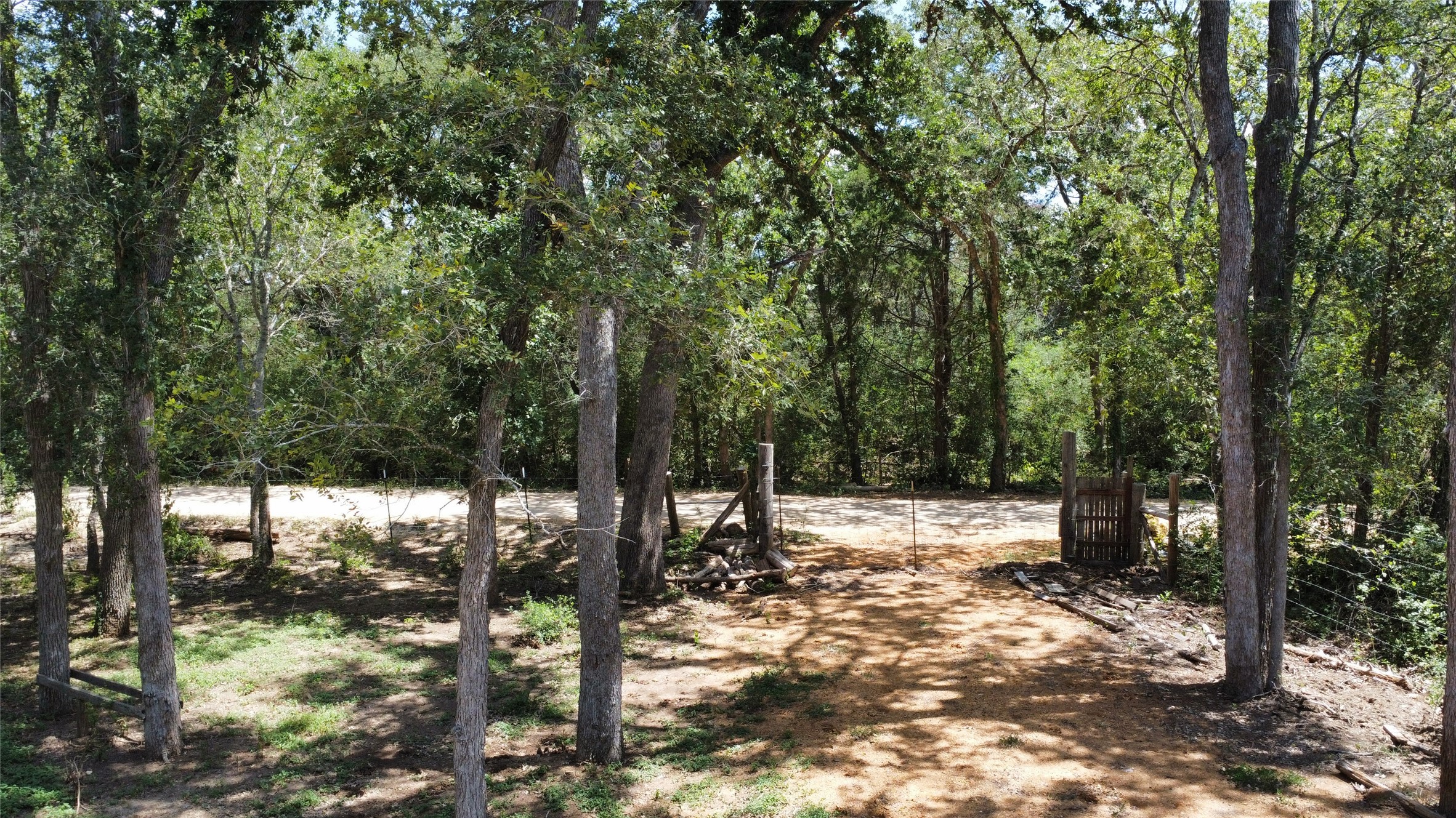 959 Carter Road Dale, TX 78616 - Photo 20 of 20 Mature trees frame a rustic gated entrance leading onto the property.