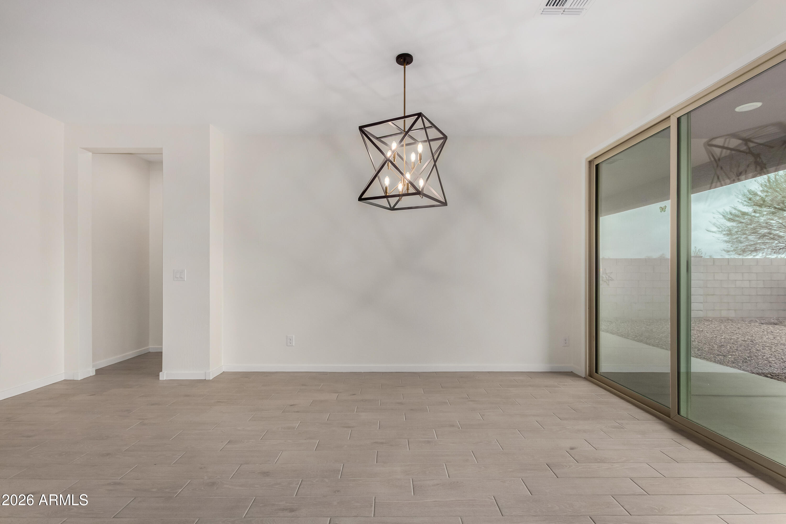 17352 West Red Fox Road Surprise, AZ 85387 - Photo 13 of 45 a view of a room with wooden floor and white walls