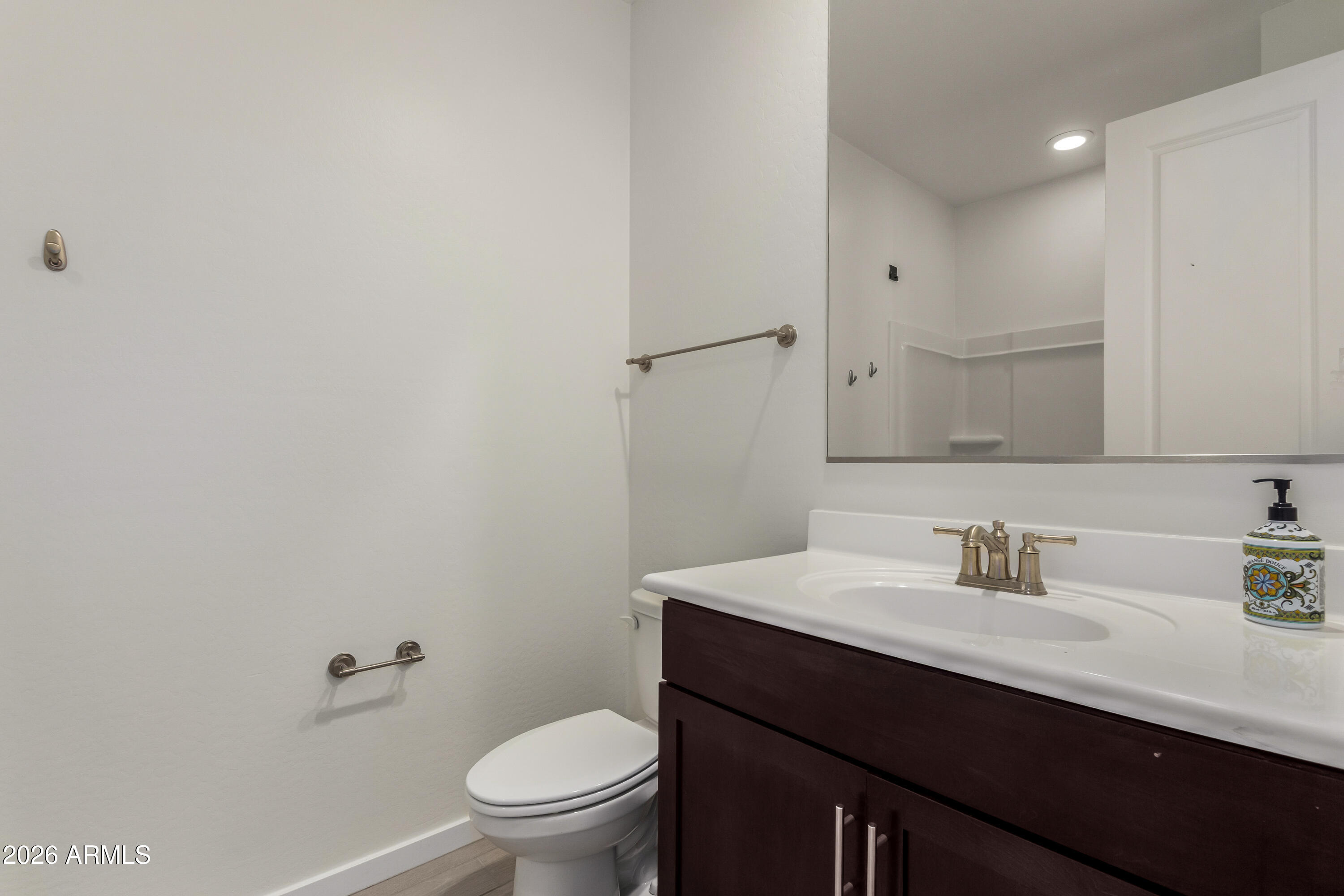 17352 West Red Fox Road Surprise, AZ 85387 - Photo 32 of 45 a bathroom with a sink a toilet a mirror and vanity