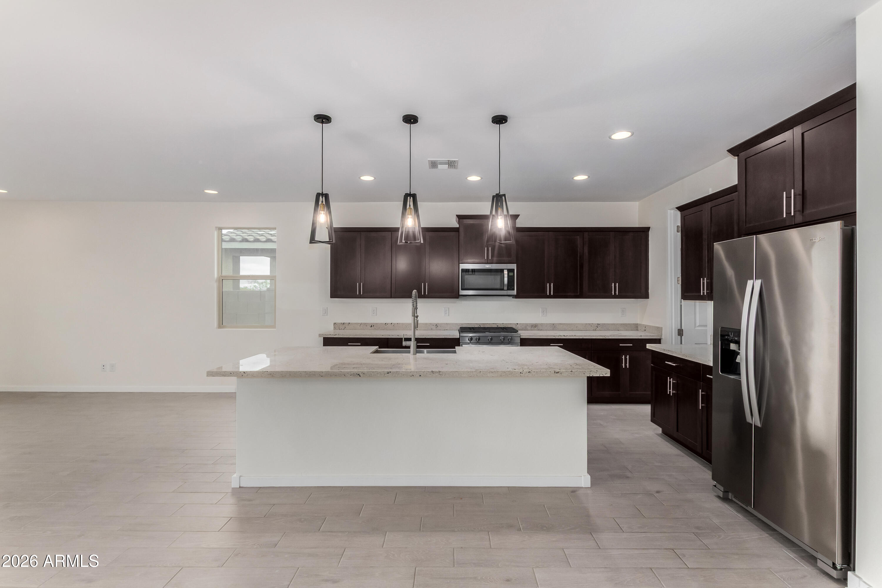 17352 West Red Fox Road Surprise, AZ 85387 - Photo 6 of 45 a large kitchen with kitchen island a large counter top stainless steel appliances and cabinets