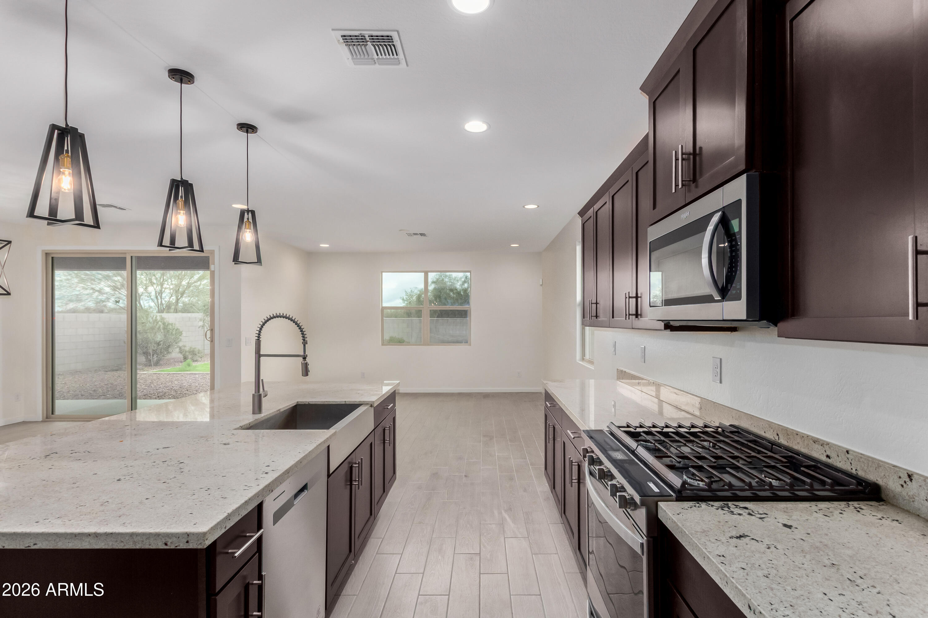 17352 West Red Fox Road Surprise, AZ 85387 - Photo 7 of 45 a kitchen with kitchen island granite countertop a stove a sink and a refrigerator