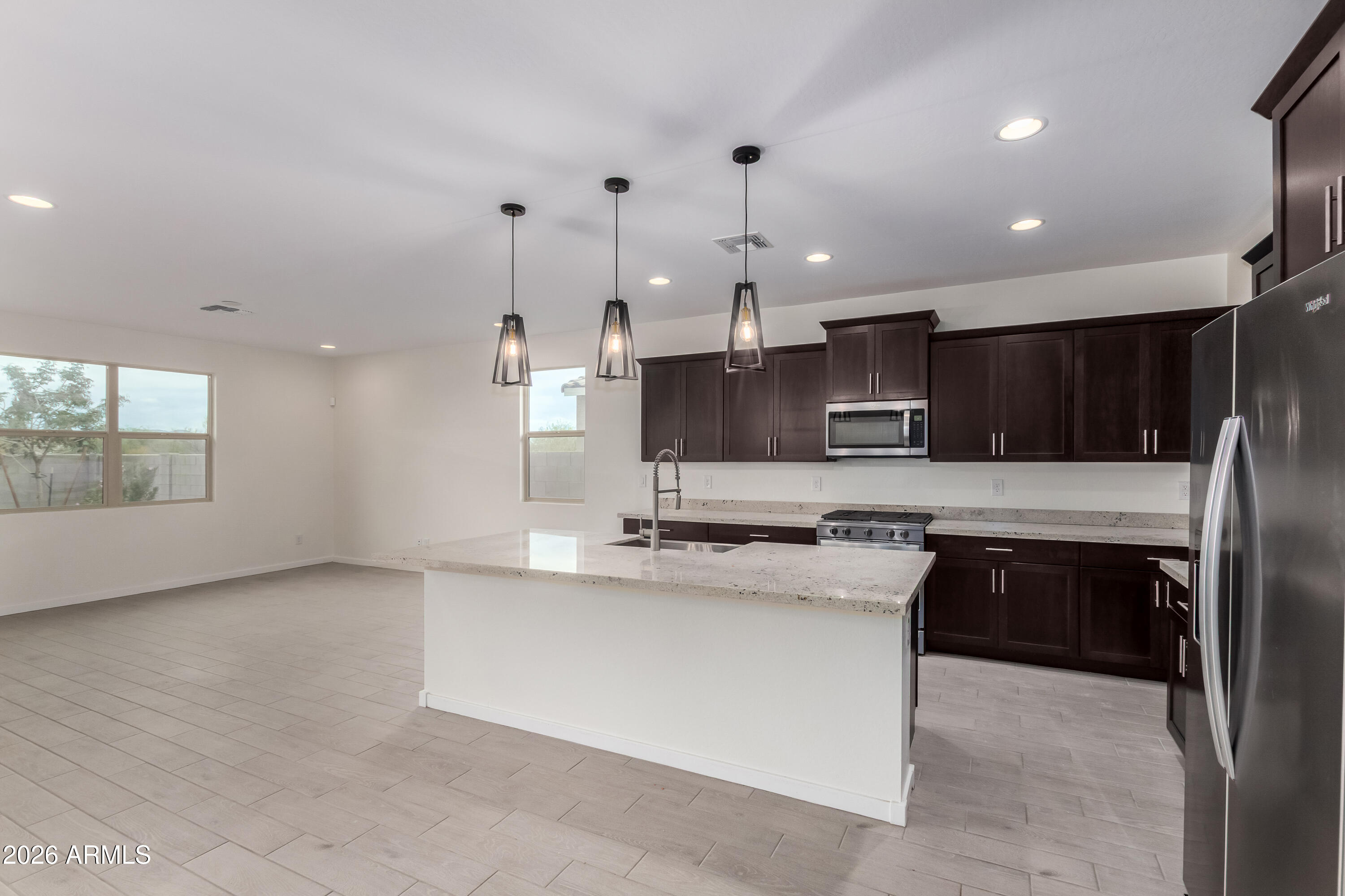 17352 West Red Fox Road Surprise, AZ 85387 - Photo 9 of 45 a kitchen with stainless steel appliances granite countertop a sink a stove and a refrigerator