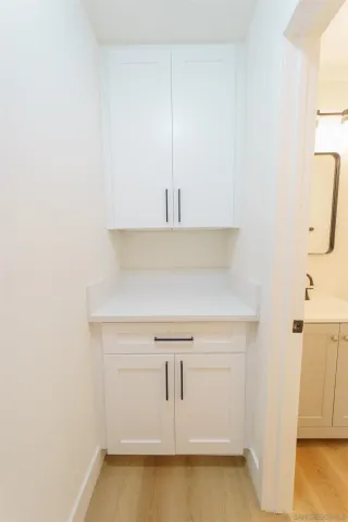 a view of a kitchen with white cabinets