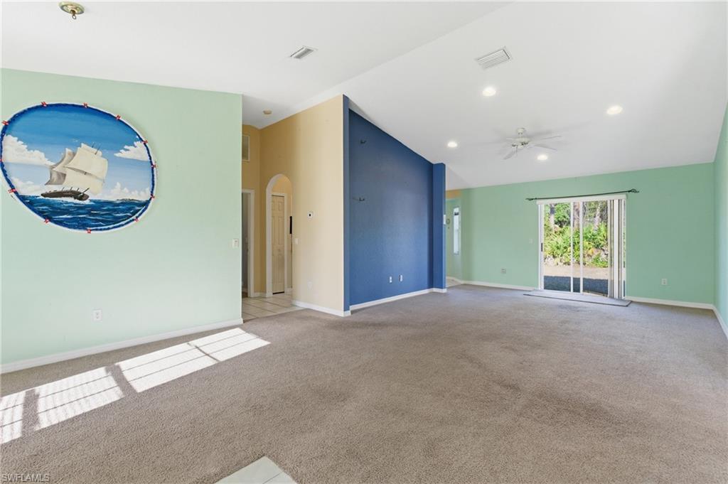 1562 Jakway Road North Port, FL 34288 - Photo 11 of 50 Empty room with vaulted ceiling, arched walkways, a ceiling fan, light carpet, and recessed lighting