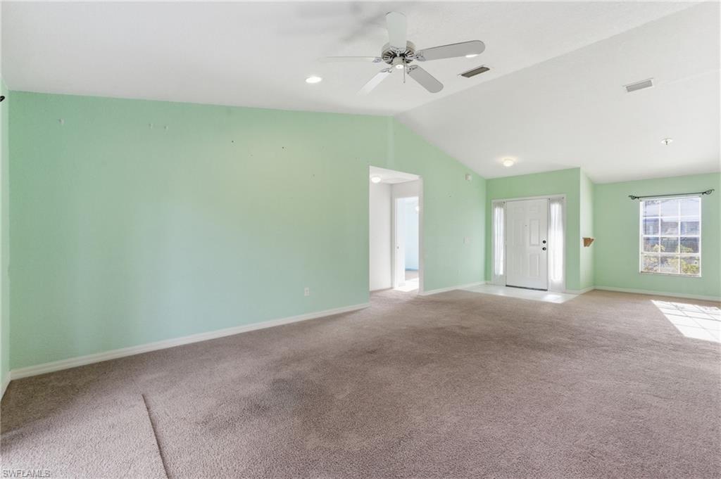 1562 Jakway Road North Port, FL 34288 - Photo 9 of 50 Unfurnished living room with ceiling fan, vaulted ceiling, and carpet flooring