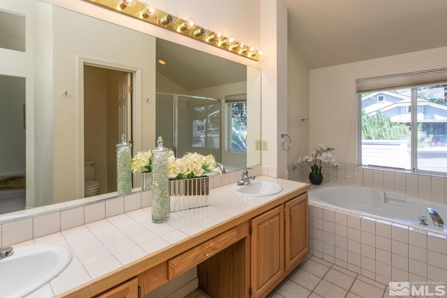 3335 Spring Creek Circle Reno, NV 89509 - Photo 12 of 30 a bathroom with a granite countertop sink mirror and a bathtub