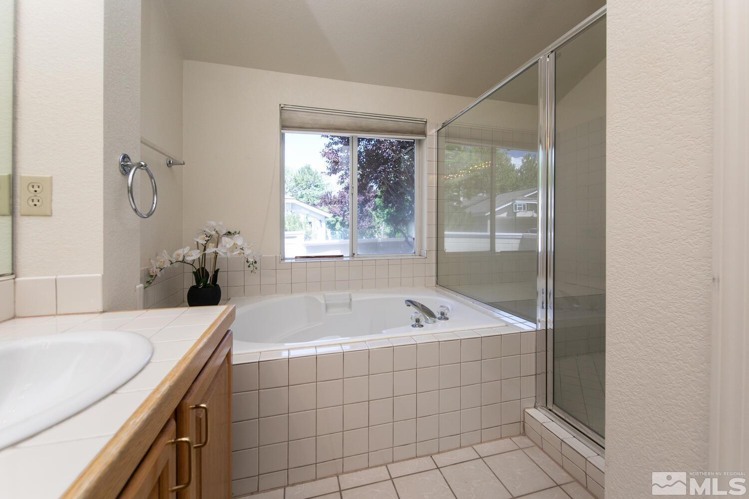 3335 Spring Creek Circle Reno, NV 89509 - Photo 13 of 30 a bathroom with a tub a sink and a window